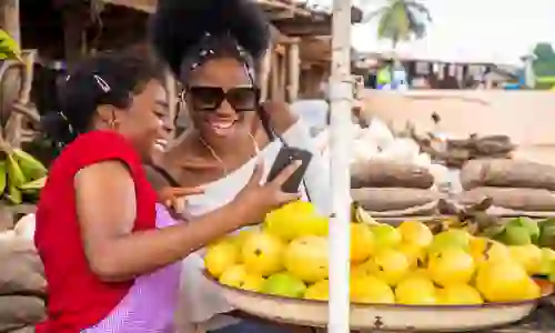 A farmer using a mobile phone in a rural market setting